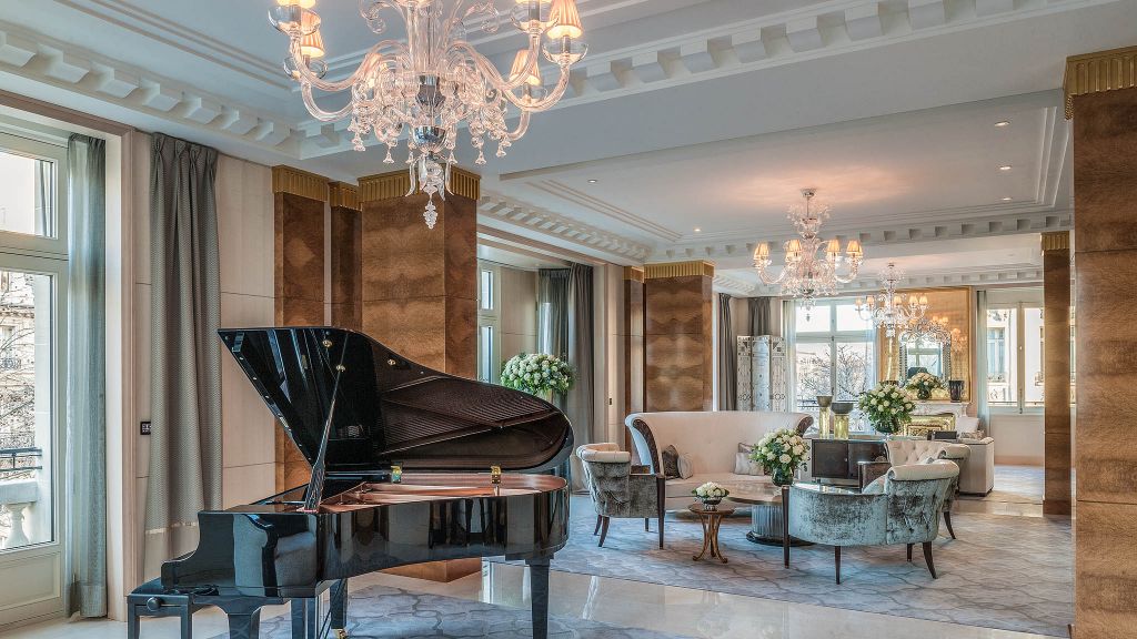 Luxurious living space with a grand piano, plush velvet seating, crystal chandeliers, and opulent décor, offering a refined atmosphere with Natlaupa