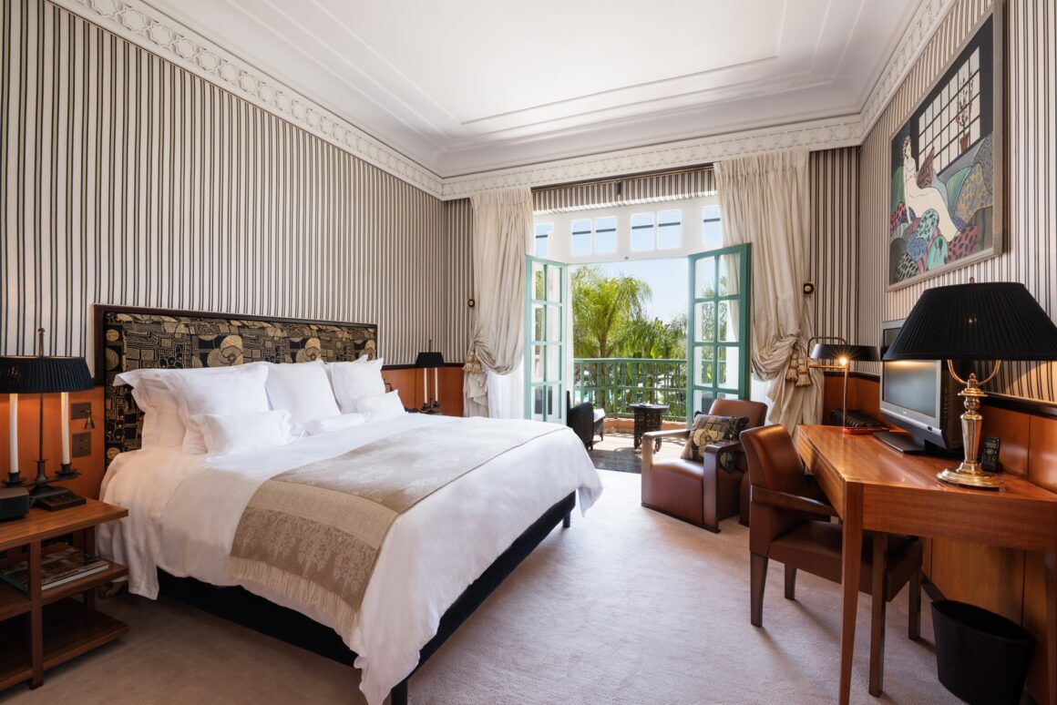 Luxurious bedroom in La Mamounia Marrakech, featuring a plush bed, cozy seating area, and elegant décor with Natlaupa.