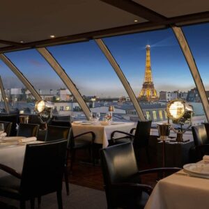 Luxurious rooftop terrace dining area in Paris with an unobstructed view of the Eiffel Tower, elegant seating, and soft ambient lighting, offering a refined experience with Natlaupa.