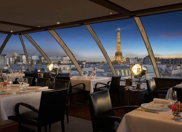 Luxurious rooftop terrace dining area in Paris with an unobstructed view of the Eiffel Tower, elegant seating, and soft ambient lighting, offering a refined experience with Natlaupa.