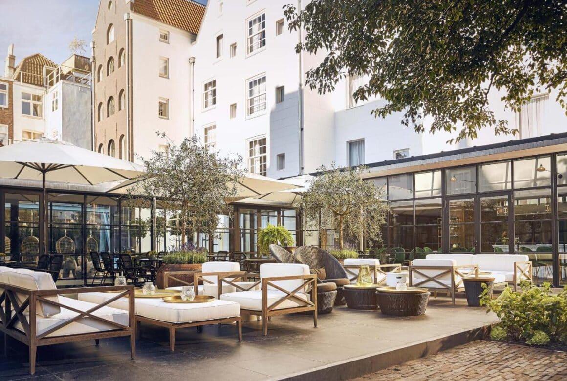 Elegant outdoor terrace at Le Pulitzer hotel Amsterdam, featuring plush seating, greenery, and sophisticated design, available with Natlaupa.