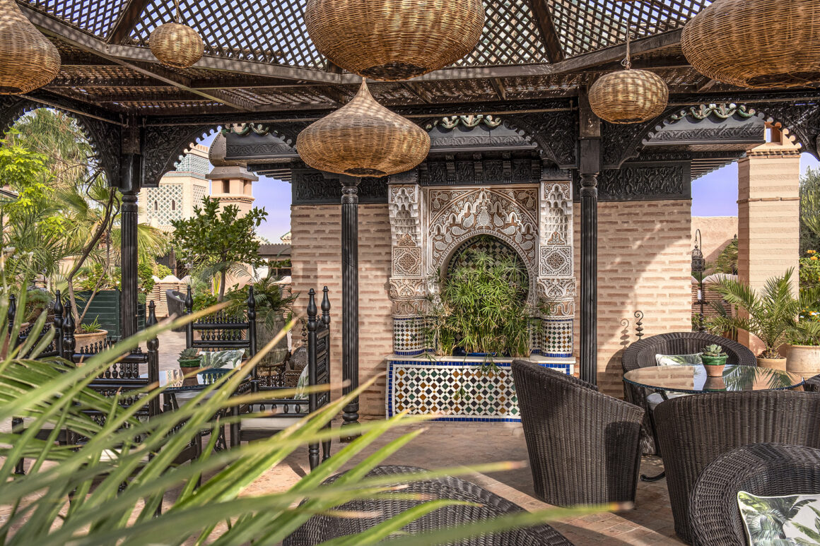 Luxurious outdoor seating area at La Sultana Marrakech with traditional Moroccan architecture and garden views, available with Natlaupa.