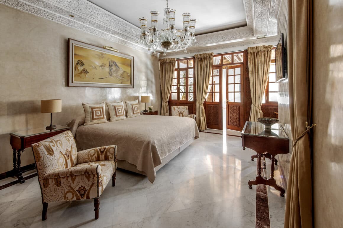 Luxurious bedroom at La Sultana Marrakech with traditional Moroccan design and modern amenities, available with Natlaupa